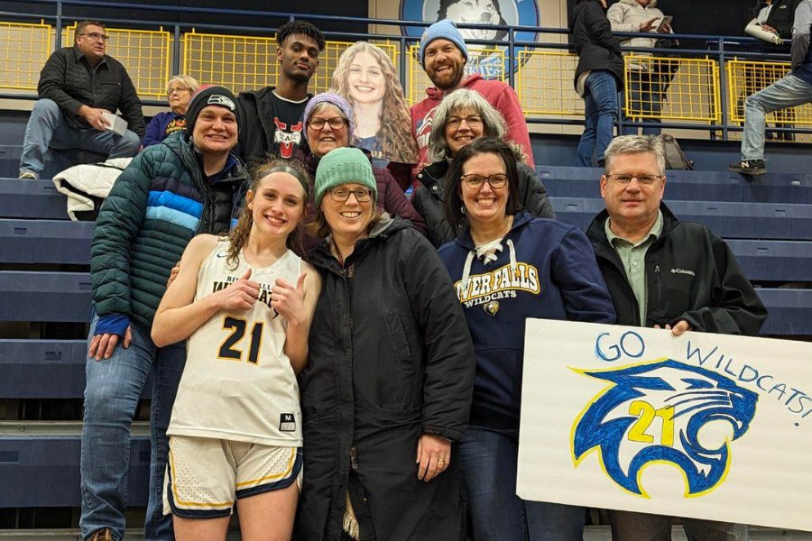 Group of fans in stands with high school senior basketball player
